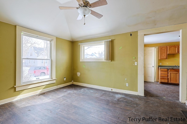 empty room with ceiling fan, sink, vaulted ceiling, and dark hardwood / wood-style floors