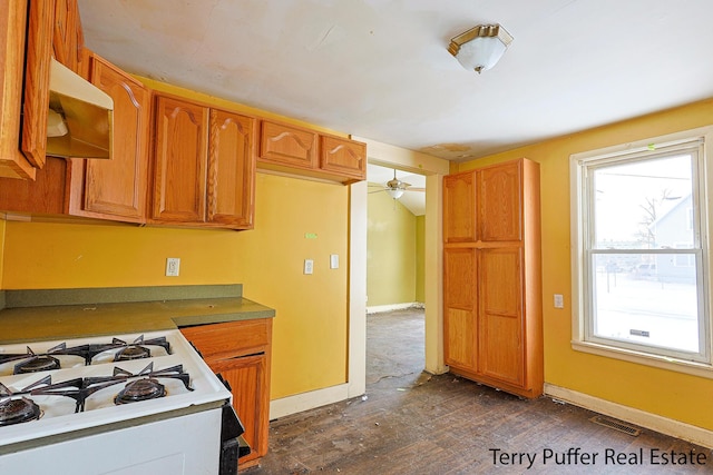 kitchen with white gas range oven, dark hardwood / wood-style floors, and extractor fan