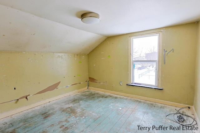 additional living space featuring light hardwood / wood-style floors and vaulted ceiling