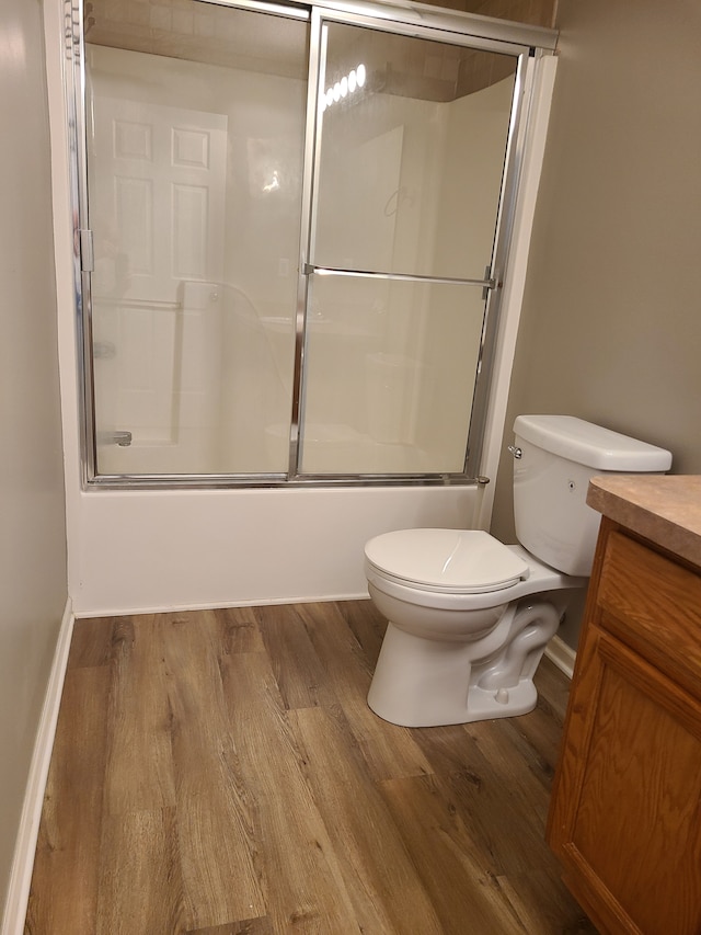 full bathroom featuring enclosed tub / shower combo, wood-type flooring, vanity, and toilet