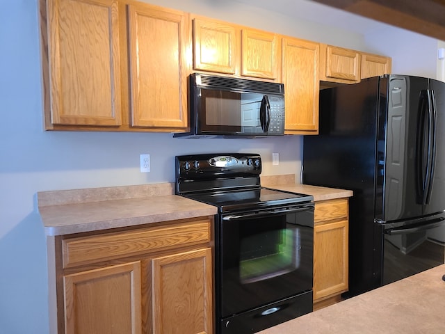 kitchen featuring light countertops, black appliances, and light brown cabinetry