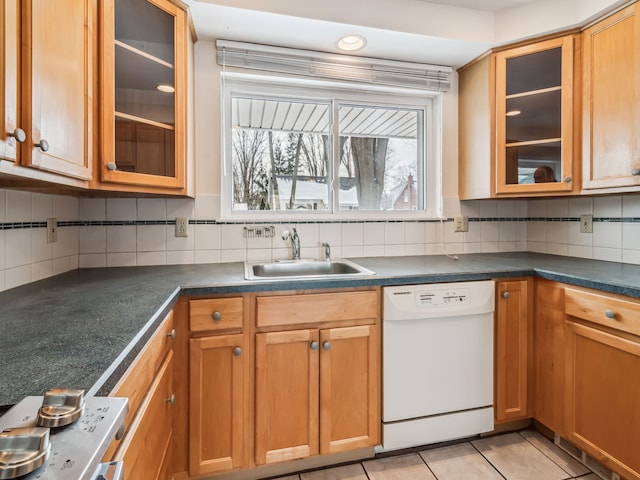 kitchen with glass insert cabinets, dark countertops, and dishwasher