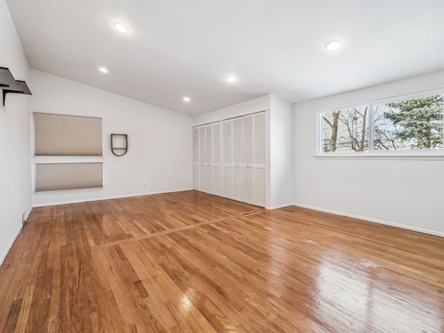 interior space featuring recessed lighting, vaulted ceiling, and wood finished floors