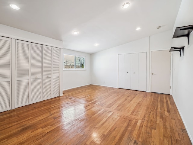 unfurnished bedroom with lofted ceiling, light wood-type flooring, and recessed lighting