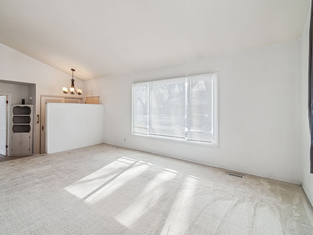 unfurnished room with light carpet, an inviting chandelier, visible vents, and vaulted ceiling