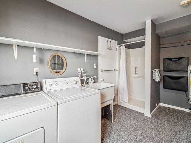 laundry area featuring baseboards, washer and clothes dryer, a sink, and dark colored carpet