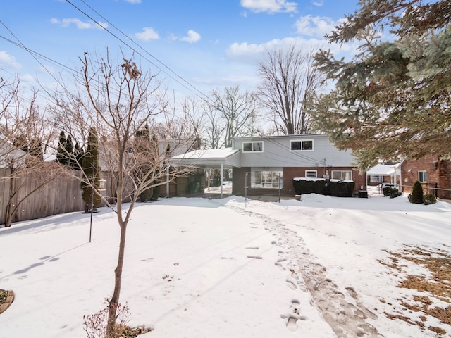 view of front of house featuring brick siding and fence