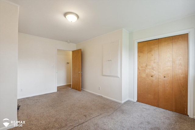 unfurnished bedroom with light carpet and a closet