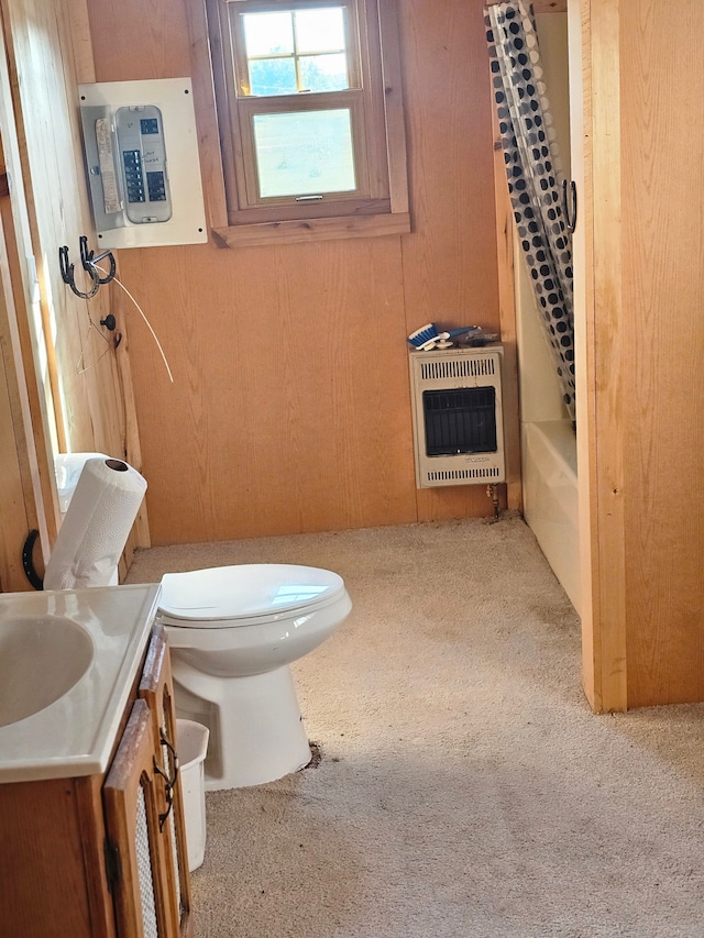 full bathroom featuring heating unit, electric panel, toilet, wooden walls, and vanity