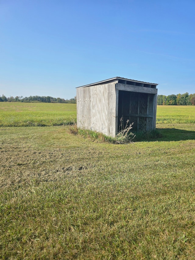 view of outbuilding with a yard and a rural view