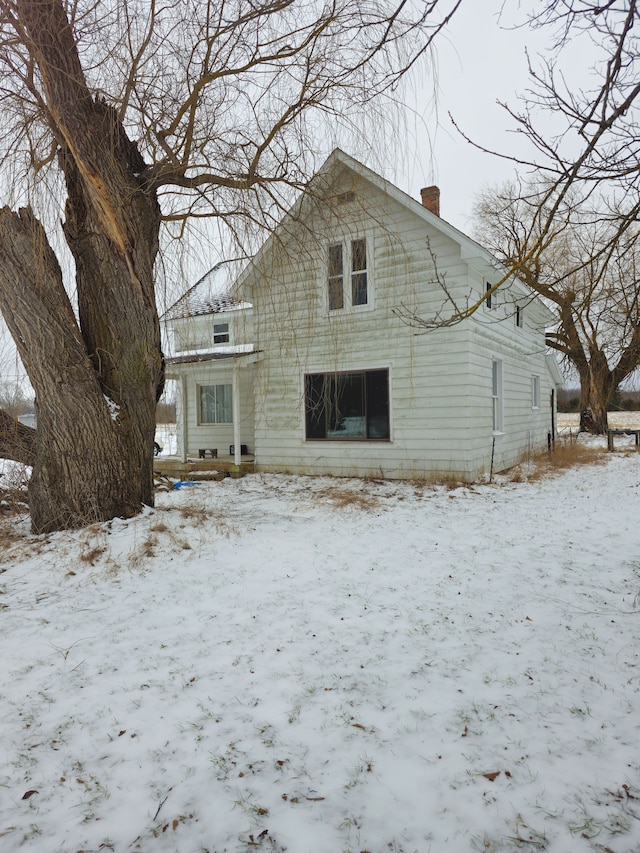 view of snow covered back of property