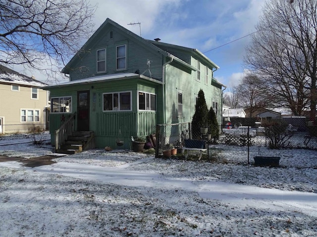 view of snow covered back of property