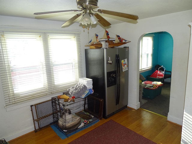 kitchen featuring ceiling fan, wood-type flooring, and stainless steel fridge with ice dispenser