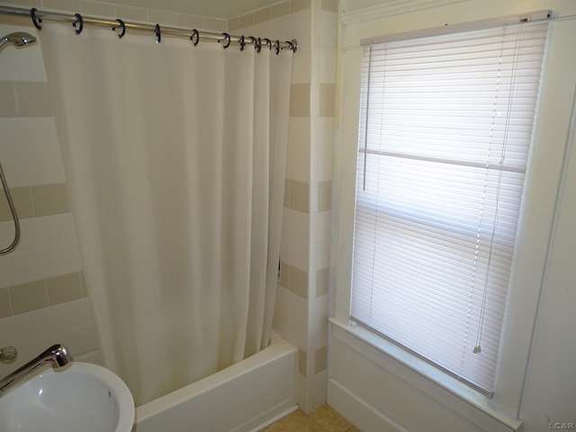 bathroom with shower / bath combination with curtain and sink