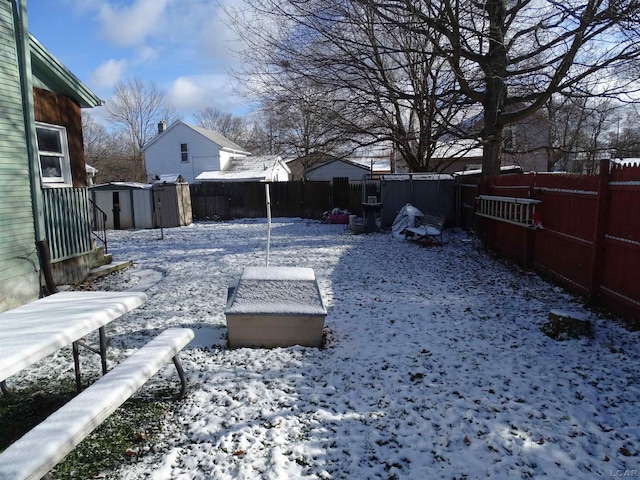 yard covered in snow featuring a storage shed