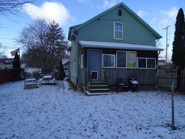 view of snow covered rear of property