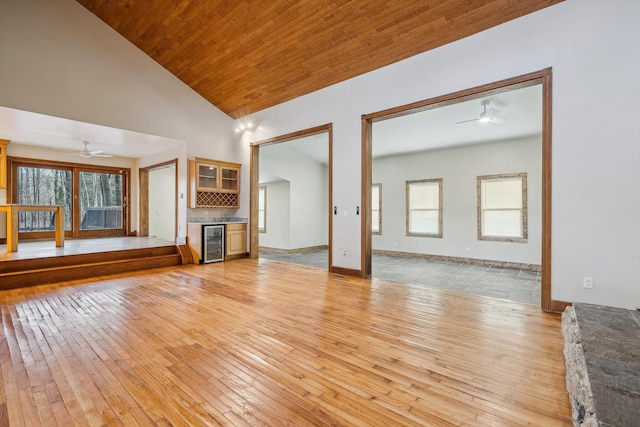 unfurnished living room with vaulted ceiling, light hardwood / wood-style flooring, ceiling fan, wood ceiling, and beverage cooler