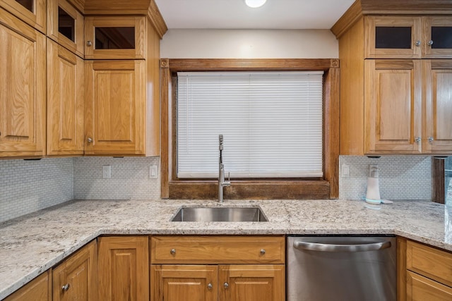 kitchen with dishwasher, backsplash, light stone countertops, and sink