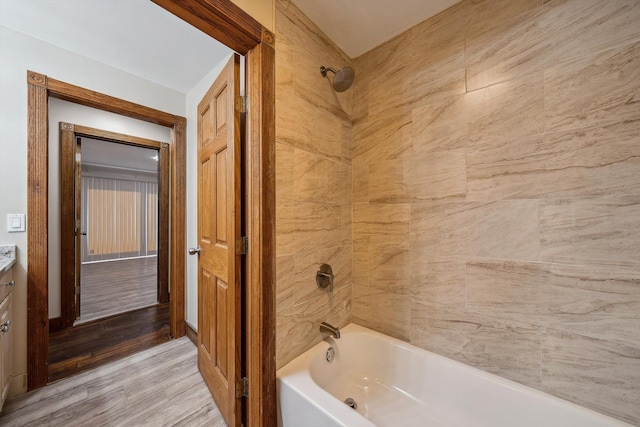 bathroom with vanity, wood-type flooring, and tiled shower / bath