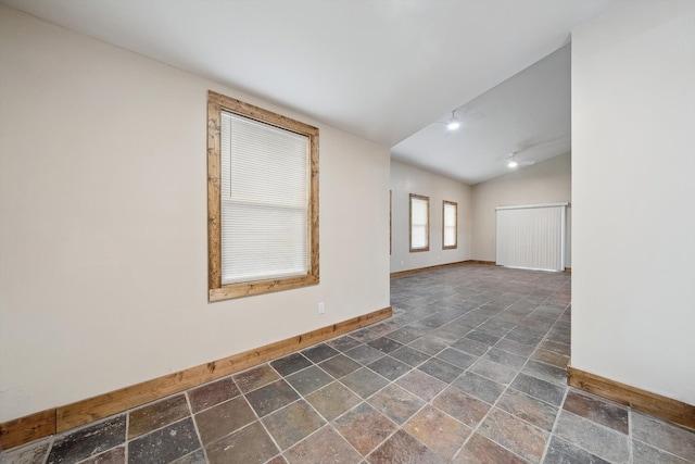 unfurnished room with vaulted ceiling