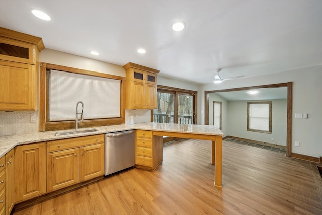 kitchen featuring light stone countertops, dishwasher, ceiling fan, sink, and tasteful backsplash