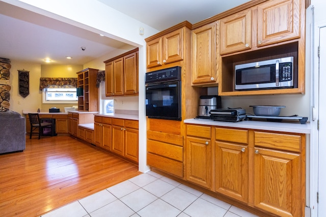 kitchen featuring light tile patterned floors and black oven