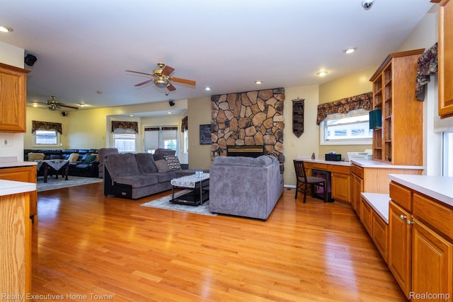 8268 Doncaster Dr, Sterling Heights, MI 48312 - living area with a fireplace, ceiling fan, light wood-style flooring, and plenty of natural light