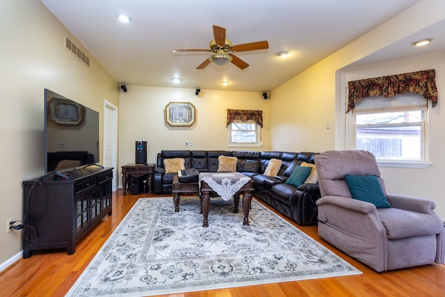 living room featuring wood-type flooring and ceiling fan