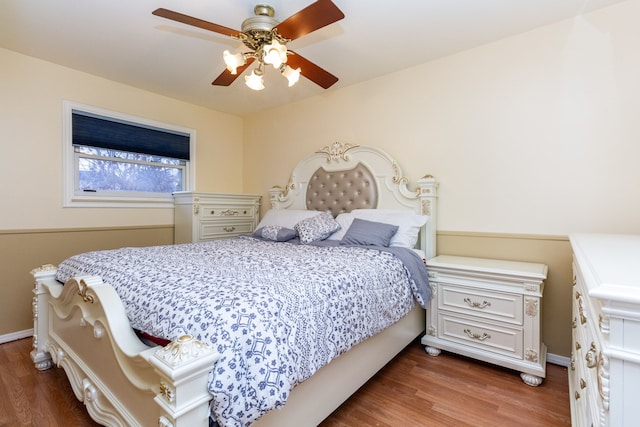 bedroom with dark hardwood / wood-style flooring and ceiling fan