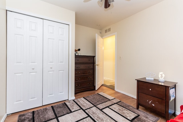 bedroom with ceiling fan, light hardwood / wood-style flooring, and a closet