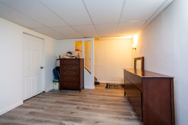 bedroom featuring light hardwood / wood-style floors and a drop ceiling