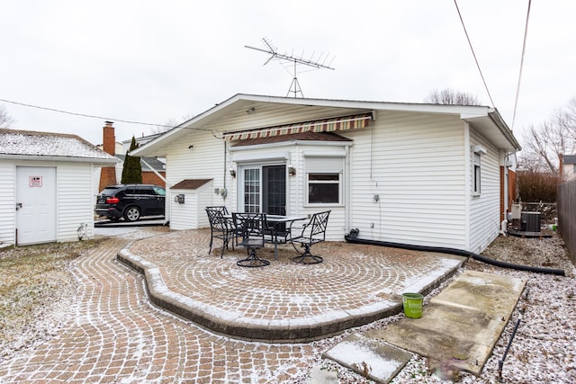 rear view of property with central air condition unit and a patio area