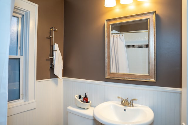 bathroom with toilet, walk in shower, and sink