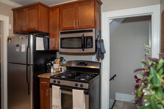 kitchen with stone countertops, crown molding, and stainless steel appliances