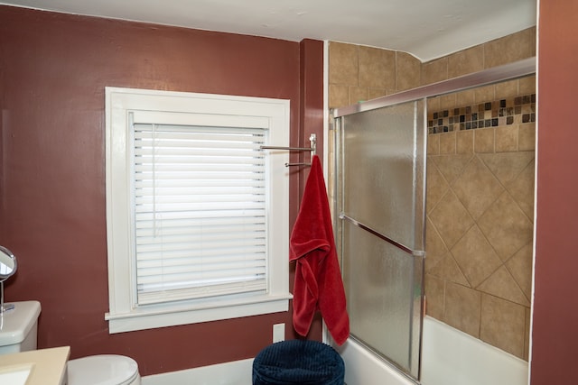 full bathroom featuring vanity, combined bath / shower with glass door, and toilet