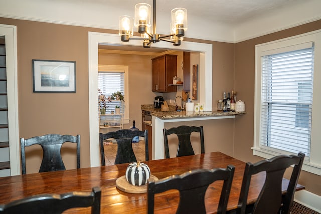 dining room with ornamental molding and an inviting chandelier