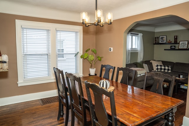 dining space featuring ornamental molding, dark hardwood / wood-style floors, and a notable chandelier