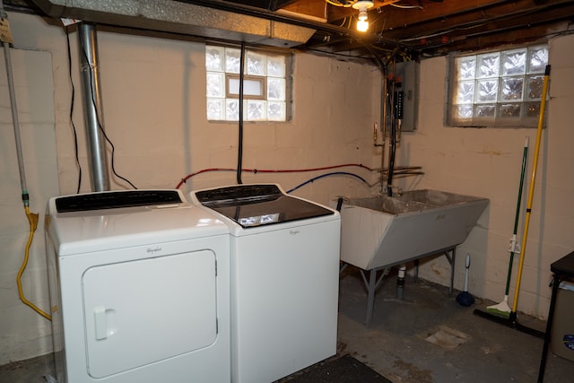 clothes washing area with electric panel, sink, and independent washer and dryer