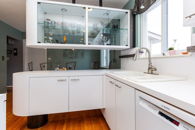 bar with sink, white cabinets, hardwood / wood-style floors, and white dishwasher