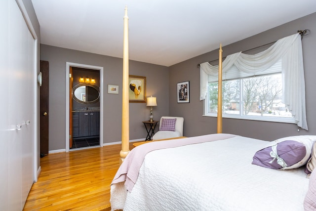 bedroom featuring ensuite bathroom and wood-type flooring