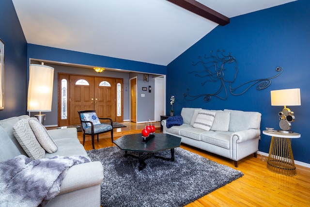 living room with vaulted ceiling with beams and hardwood / wood-style flooring