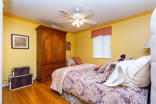 bedroom with ceiling fan, light wood-type flooring, and ornamental molding