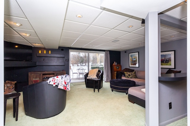 carpeted living room with a paneled ceiling