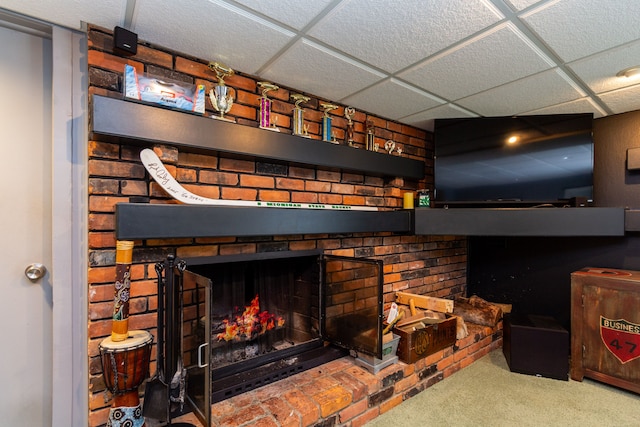 interior details featuring a paneled ceiling, a fireplace, and carpet floors