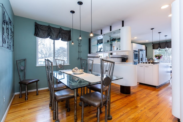 dining room featuring light wood-type flooring and a wealth of natural light