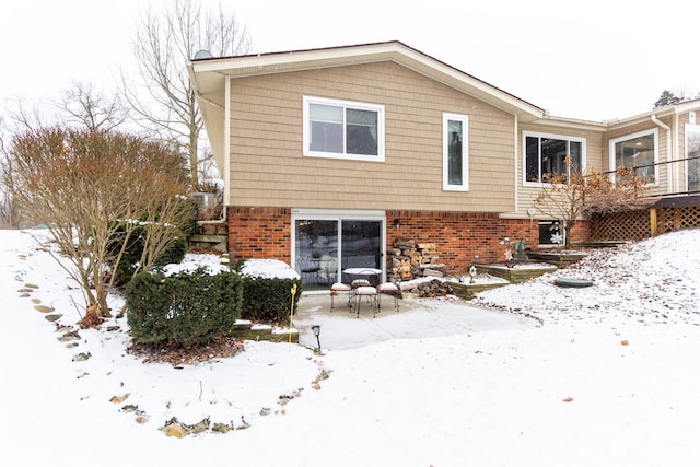 view of snow covered back of property