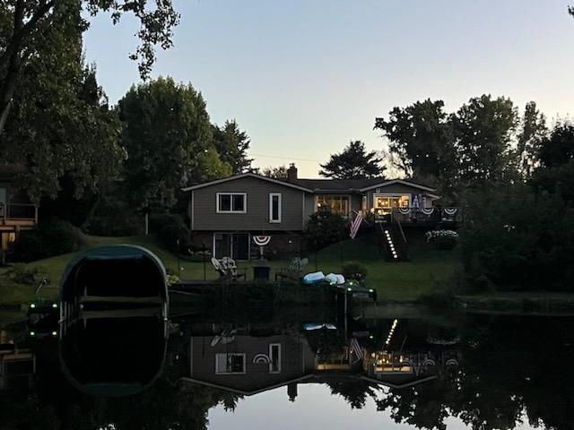 back house at dusk with a lawn