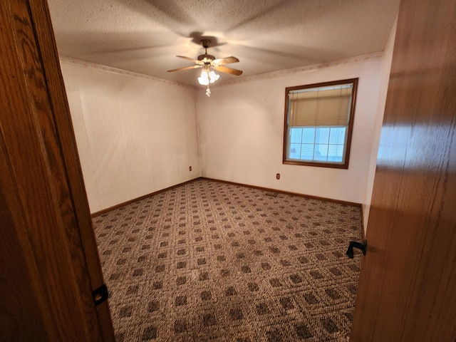 unfurnished room with ceiling fan, a textured ceiling, and dark colored carpet