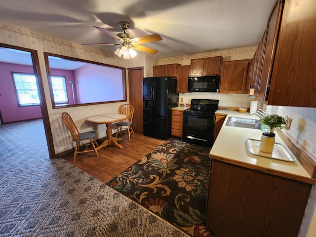 kitchen featuring dark hardwood / wood-style flooring, sink, ceiling fan, and black appliances
