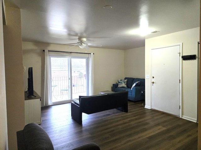 living room with ceiling fan and dark wood-type flooring